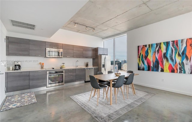 kitchen featuring visible vents, concrete floors, appliances with stainless steel finishes, and a sink