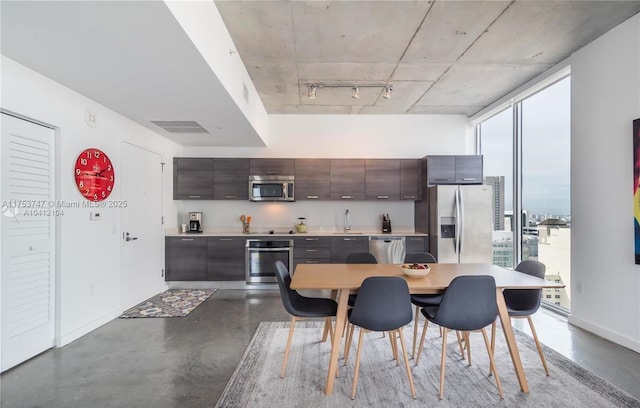 kitchen featuring a healthy amount of sunlight, visible vents, appliances with stainless steel finishes, and dark brown cabinets