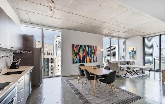 dining area with a wall of windows, finished concrete floors, and plenty of natural light