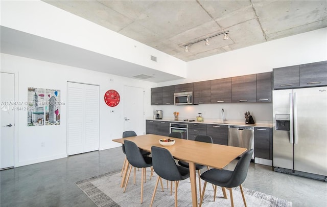 dining room with visible vents, concrete floors, and baseboards