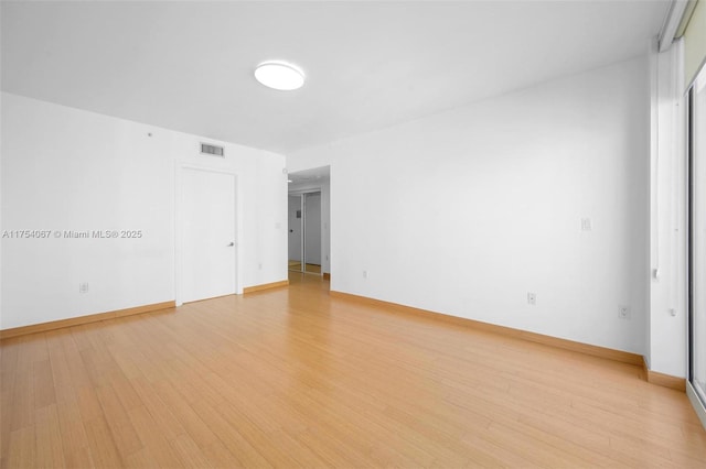 unfurnished room featuring baseboards, visible vents, and light wood finished floors