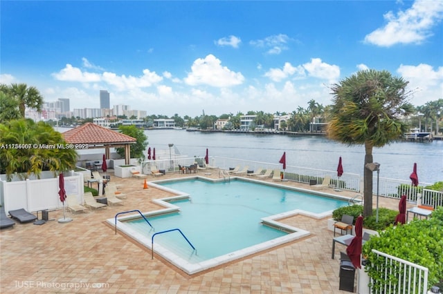 pool with a gazebo, a patio area, fence, and a water view