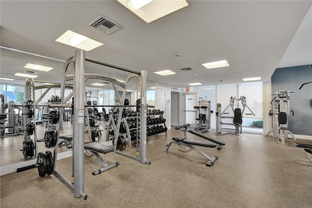 exercise room with a wall of windows, visible vents, and baseboards