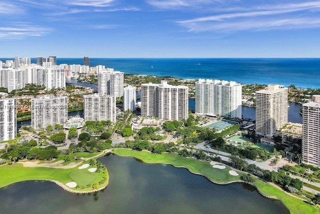 drone / aerial view featuring golf course view, a water view, and a city view