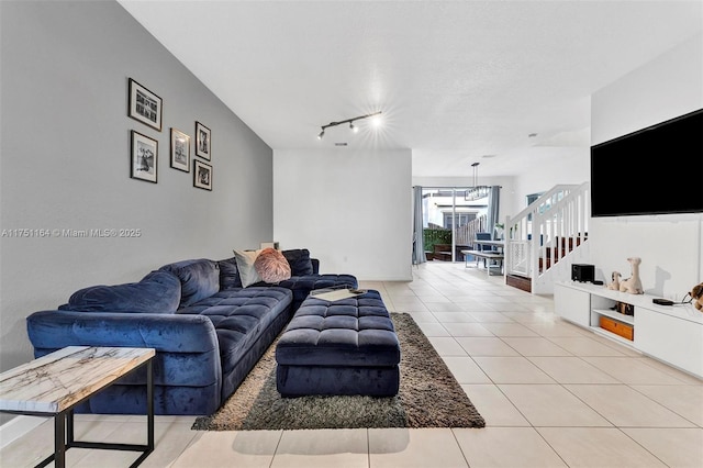 living room featuring light tile patterned floors, a textured ceiling, stairs, and rail lighting