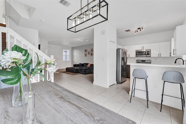 kitchen with light tile patterned floors, light countertops, visible vents, appliances with stainless steel finishes, and open floor plan