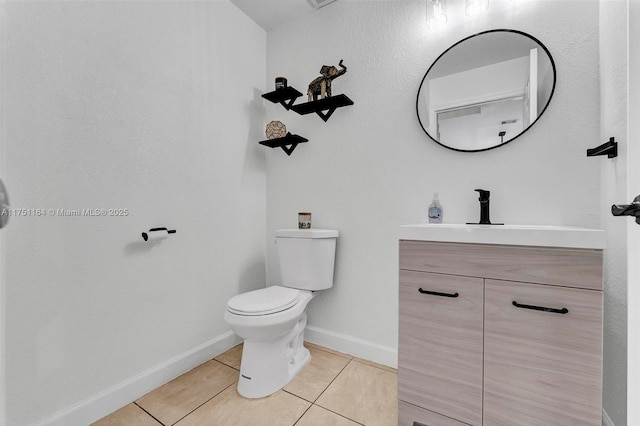 bathroom featuring tile patterned flooring, baseboards, vanity, and toilet