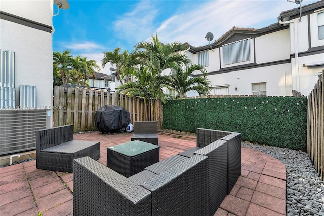 view of patio with a grill, fence, and an outdoor living space