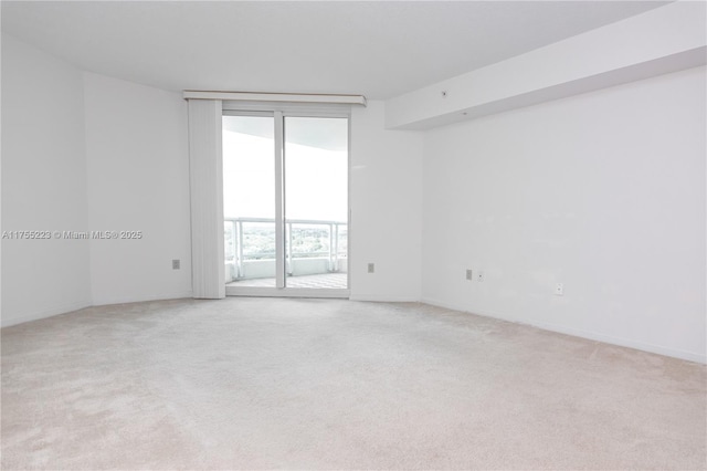 spare room with light carpet and baseboards