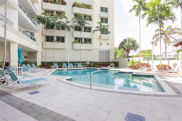 community pool featuring a patio area and fence