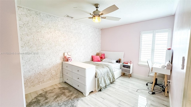 bedroom with visible vents, light wood-style flooring, ceiling fan, baseboards, and wallpapered walls