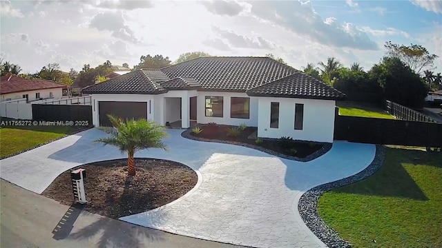 view of front facade with stucco siding, curved driveway, a front lawn, a garage, and a tile roof