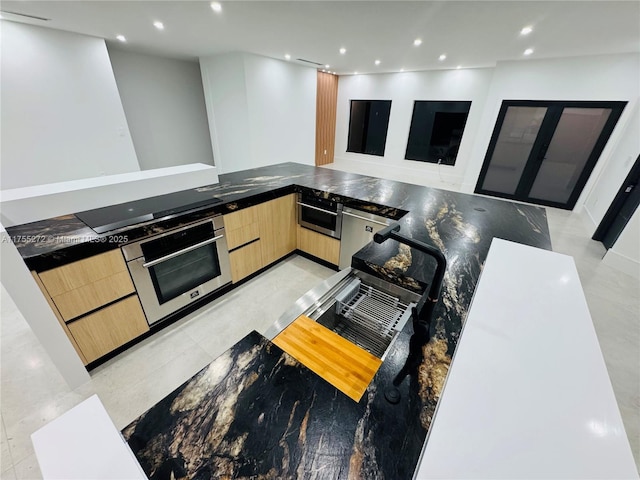 kitchen featuring recessed lighting, light brown cabinets, modern cabinets, and oven