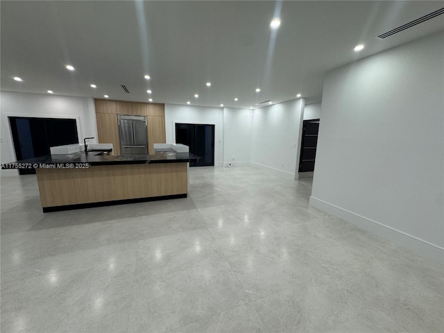 unfurnished living room with recessed lighting, visible vents, baseboards, and a sink