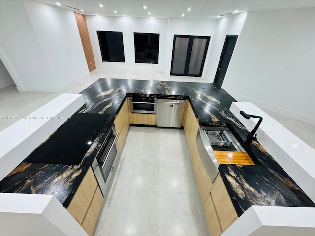 kitchen featuring modern cabinets, light brown cabinets, recessed lighting, appliances with stainless steel finishes, and baseboards