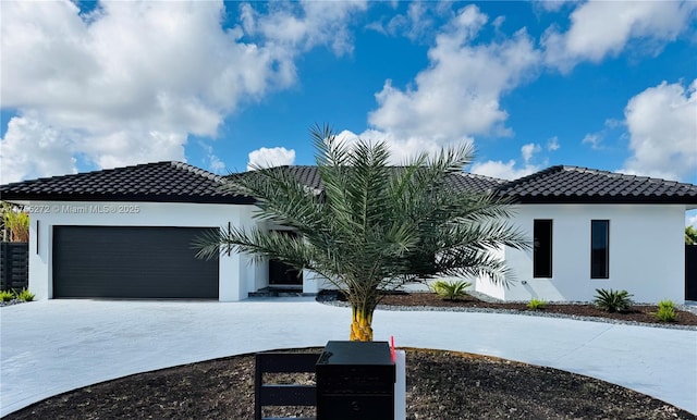 view of front of property with a tile roof, an attached garage, and stucco siding