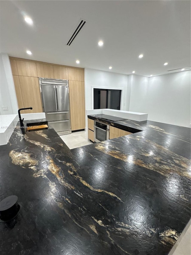 kitchen with visible vents, modern cabinets, light brown cabinetry, recessed lighting, and appliances with stainless steel finishes