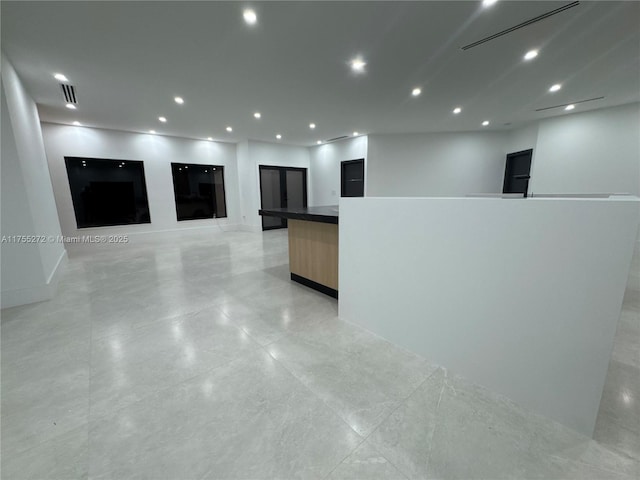 spare room featuring recessed lighting, visible vents, and baseboards