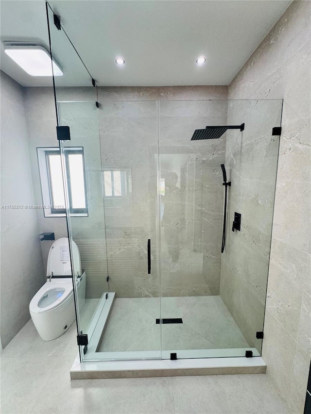 bathroom with toilet, tile walls, and a shower stall