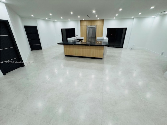 kitchen featuring baseboards, recessed lighting, dark countertops, modern cabinets, and open floor plan