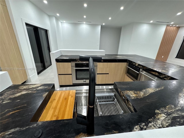 kitchen with oven, light brown cabinets, modern cabinets, and recessed lighting