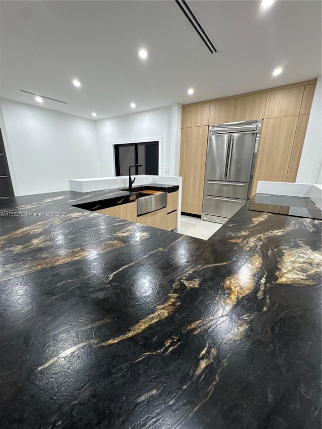 kitchen featuring light brown cabinets, high end refrigerator, recessed lighting, modern cabinets, and a sink