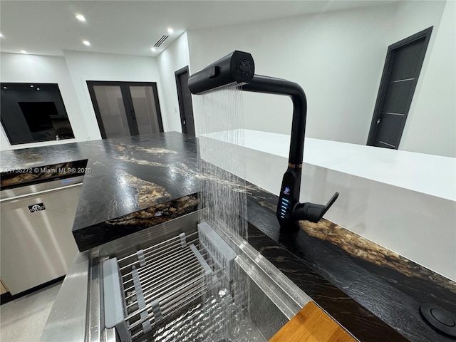 interior space with visible vents, stainless steel dishwasher, dark countertops, recessed lighting, and french doors