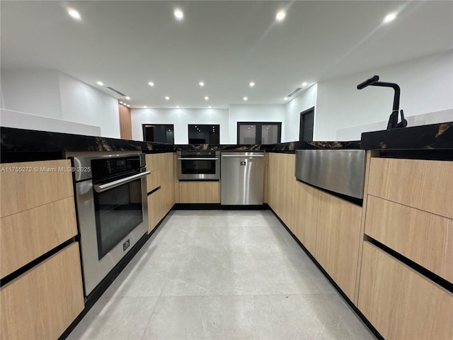 kitchen with light brown cabinets, recessed lighting, and appliances with stainless steel finishes