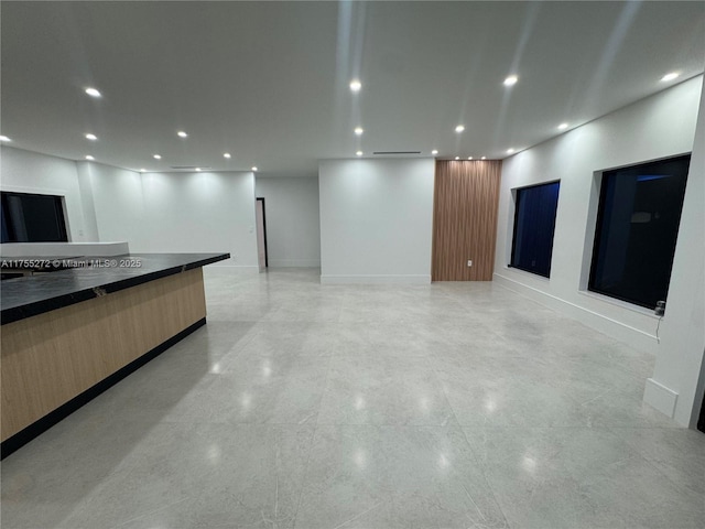 unfurnished living room featuring recessed lighting and baseboards