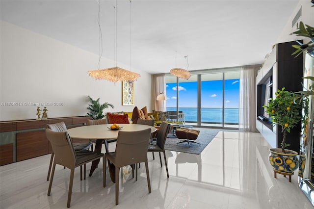 dining space featuring a water view, visible vents, and a wall of windows