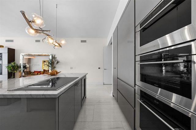 kitchen with light stone counters, gray cabinetry, visible vents, hanging light fixtures, and modern cabinets