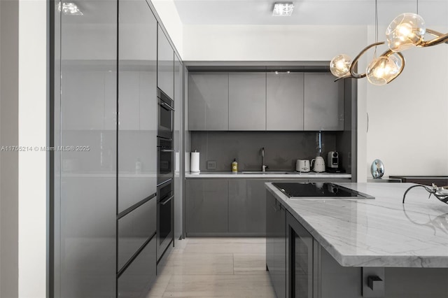 kitchen featuring black appliances, modern cabinets, a sink, and gray cabinetry