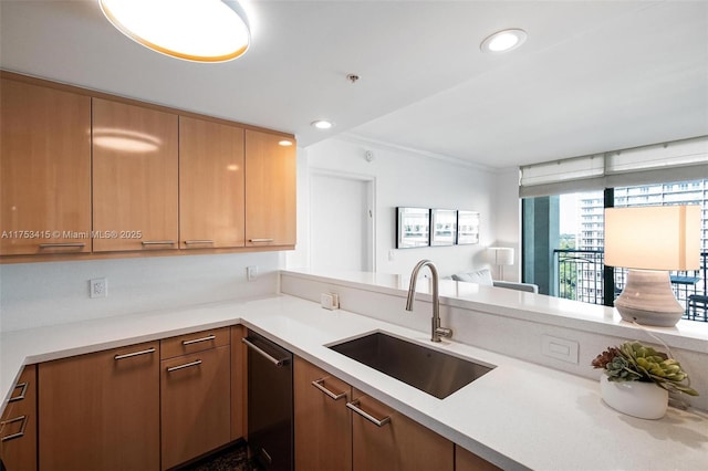 kitchen with dishwasher, light countertops, a sink, and recessed lighting