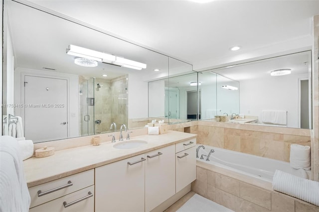 bathroom with a stall shower, a garden tub, vanity, and recessed lighting