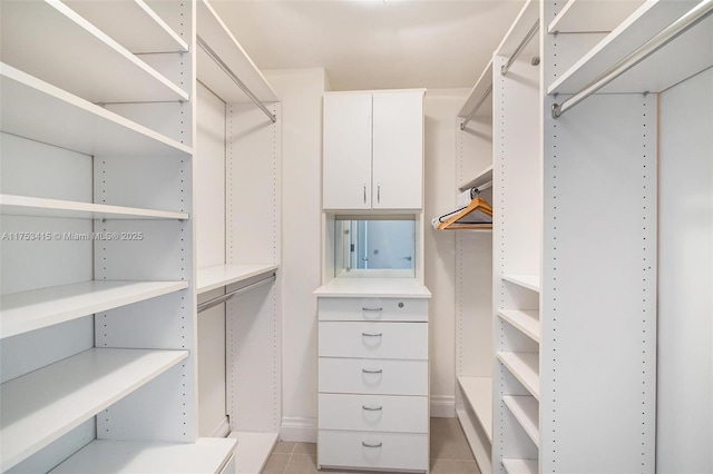 walk in closet with light tile patterned flooring