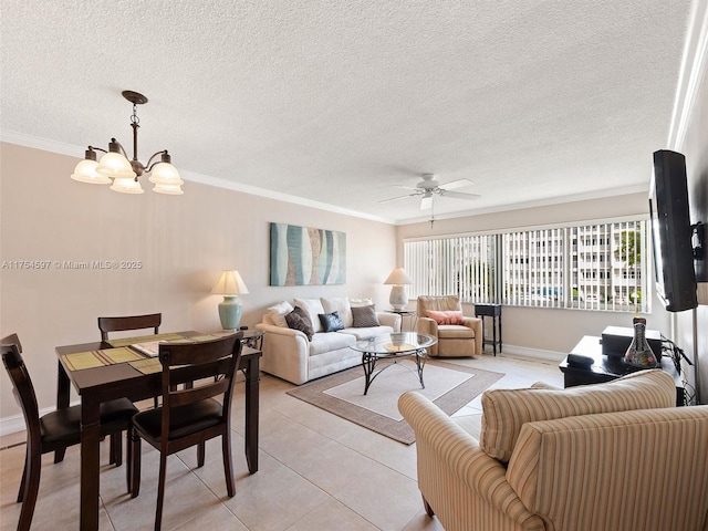 living area featuring baseboards, light tile patterned flooring, a textured ceiling, crown molding, and ceiling fan with notable chandelier