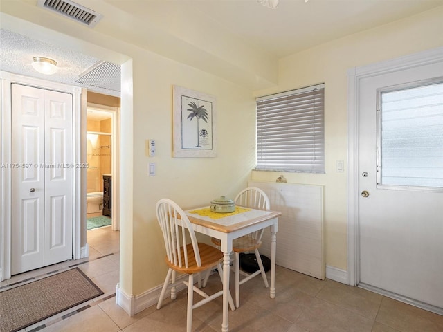 dining area with light tile patterned flooring, visible vents, and baseboards