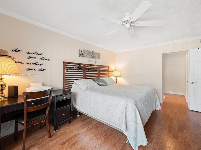 bedroom with ceiling fan, crown molding, baseboards, and wood finished floors