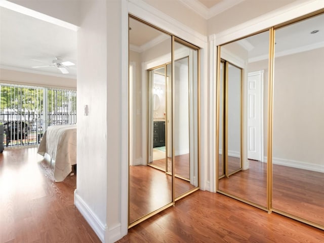 hall with baseboards, wood finished floors, and crown molding