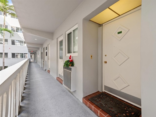 doorway to property with a balcony and stucco siding