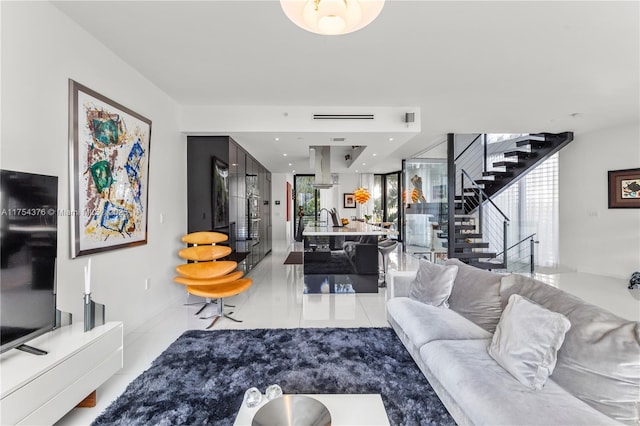 living area featuring light tile patterned floors, stairway, and a wealth of natural light