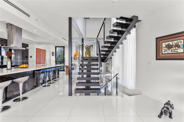 stairs featuring tile patterned flooring and recessed lighting