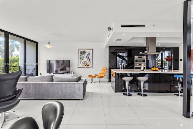 living area featuring expansive windows, tile patterned flooring, and visible vents