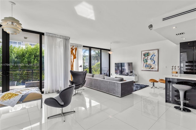 living room featuring a healthy amount of sunlight, expansive windows, and visible vents