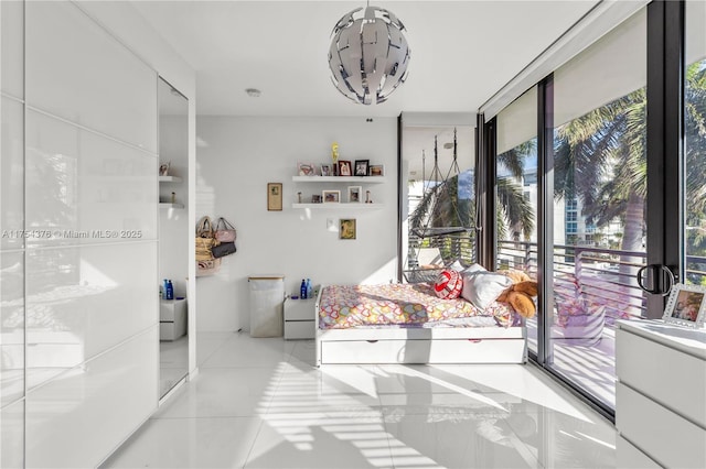 tiled bedroom featuring floor to ceiling windows and a chandelier