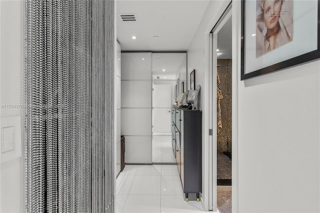 corridor with visible vents and light tile patterned floors