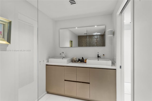 full bath featuring tile patterned flooring, visible vents, a sink, and a walk in shower