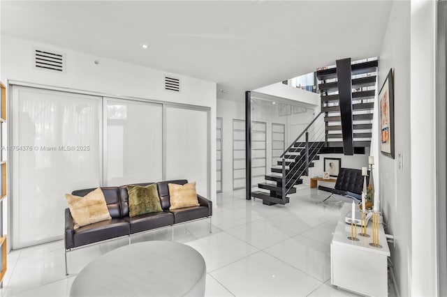 tiled living room featuring recessed lighting, visible vents, and stairs