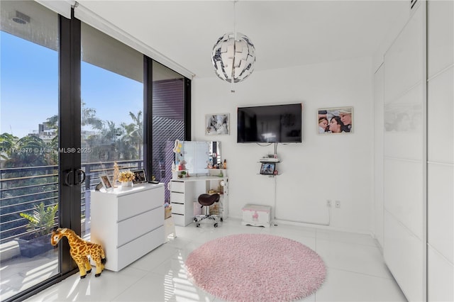 bedroom with a chandelier, floor to ceiling windows, and light tile patterned floors