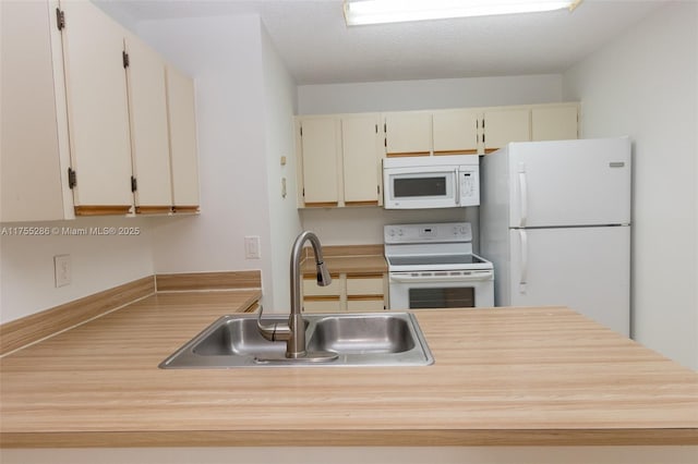 kitchen with white appliances, light countertops, and a sink